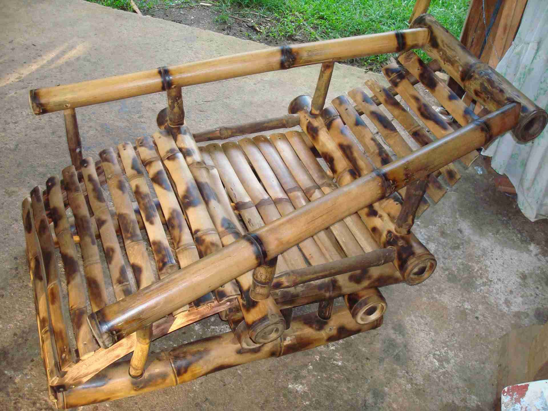 Outdoor bamboo lounge chair with a slatted seat and long bamboo arms