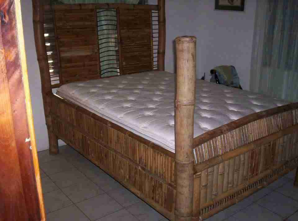 Bed frame with bamboo slat side panels and a tall bamboo corner post