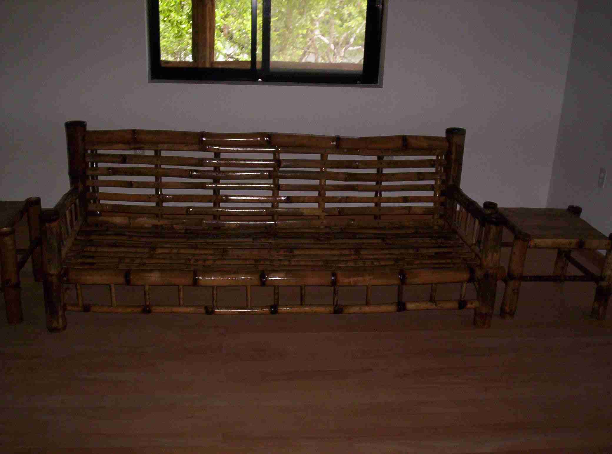 Long bamboo sofa bench with an open slatted back in a living room