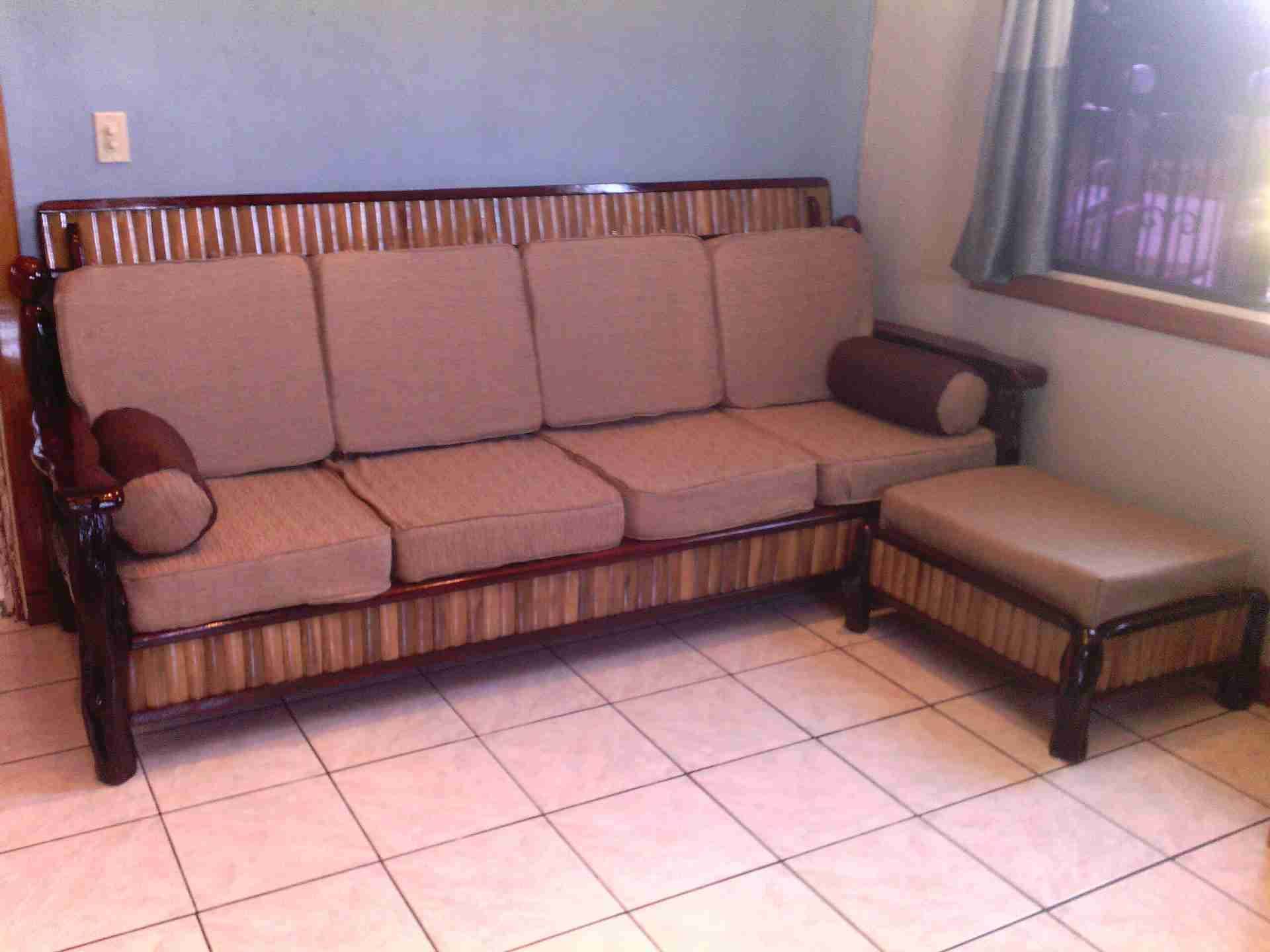 Bamboo-framed sofa with striped bamboo detail, tan cushions and a matching ottoman