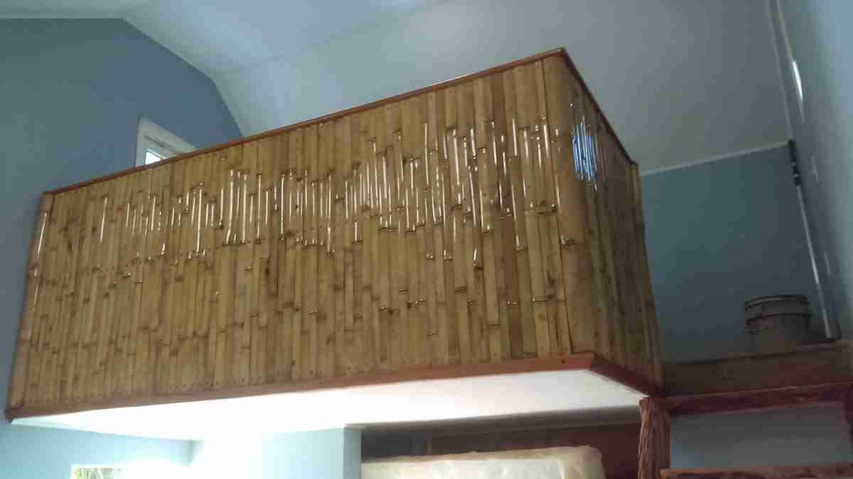 Split-bamboo wall paneling on a loft wall and railing