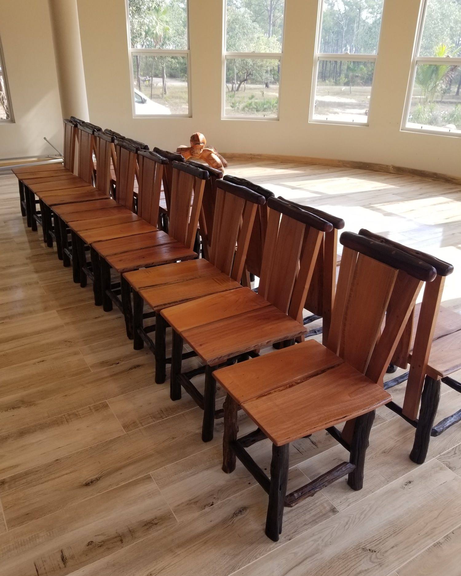 Long row of matching hardwood dining chairs ready for a restaurant