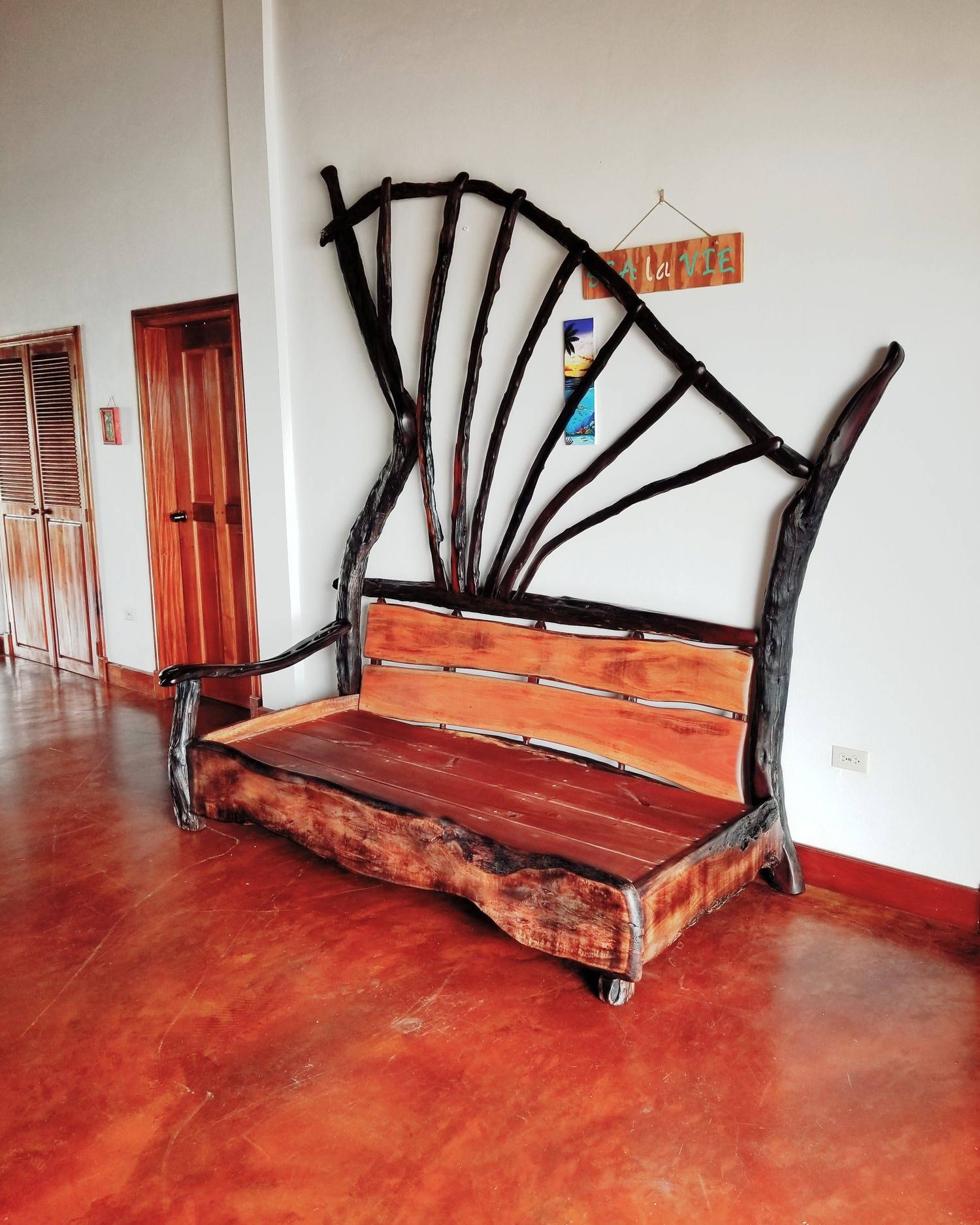 Settee with a tall fan of radiating logwood branches behind a hardwood seat