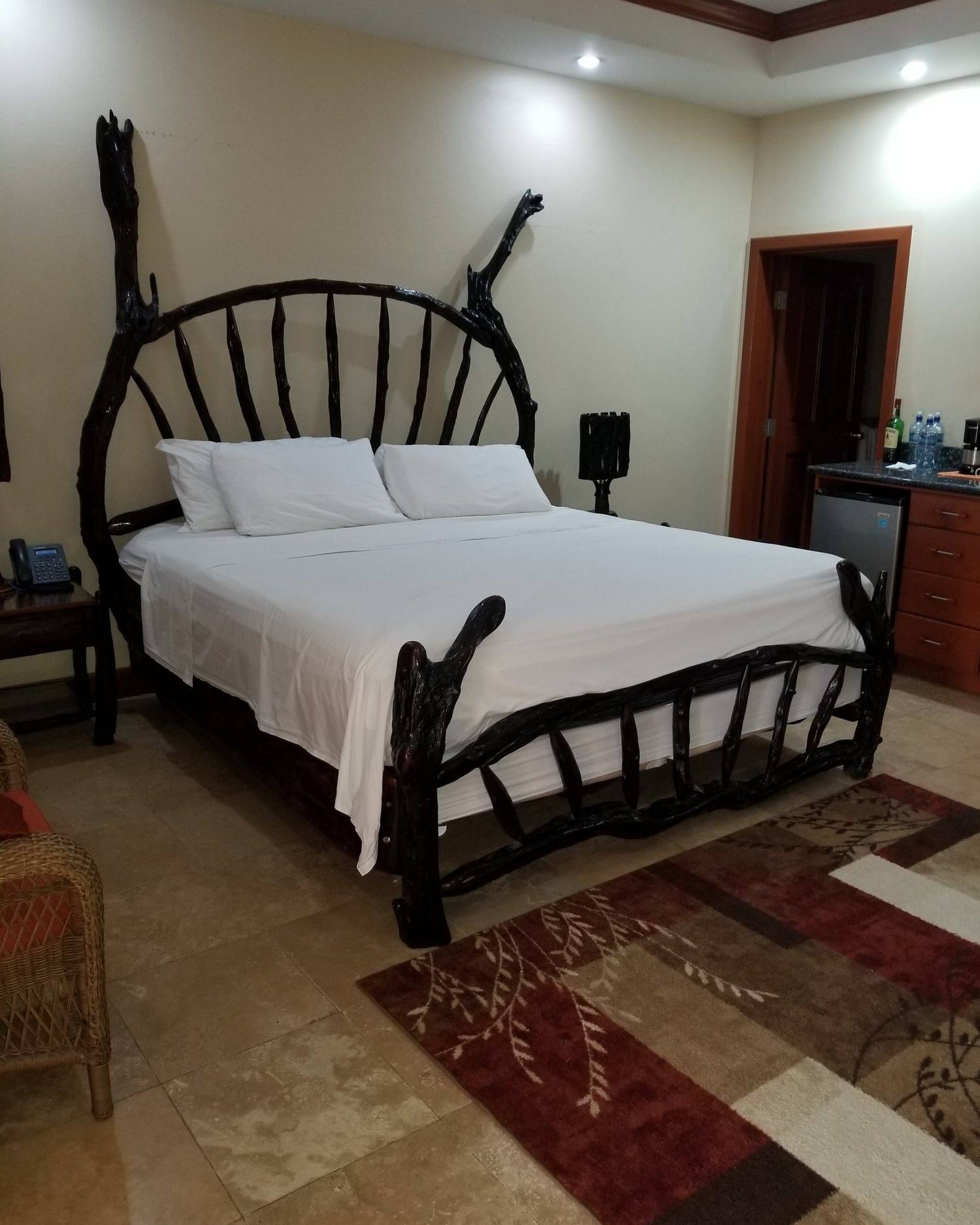 King bed with a fan-shaped logwood branch headboard in a guest suite