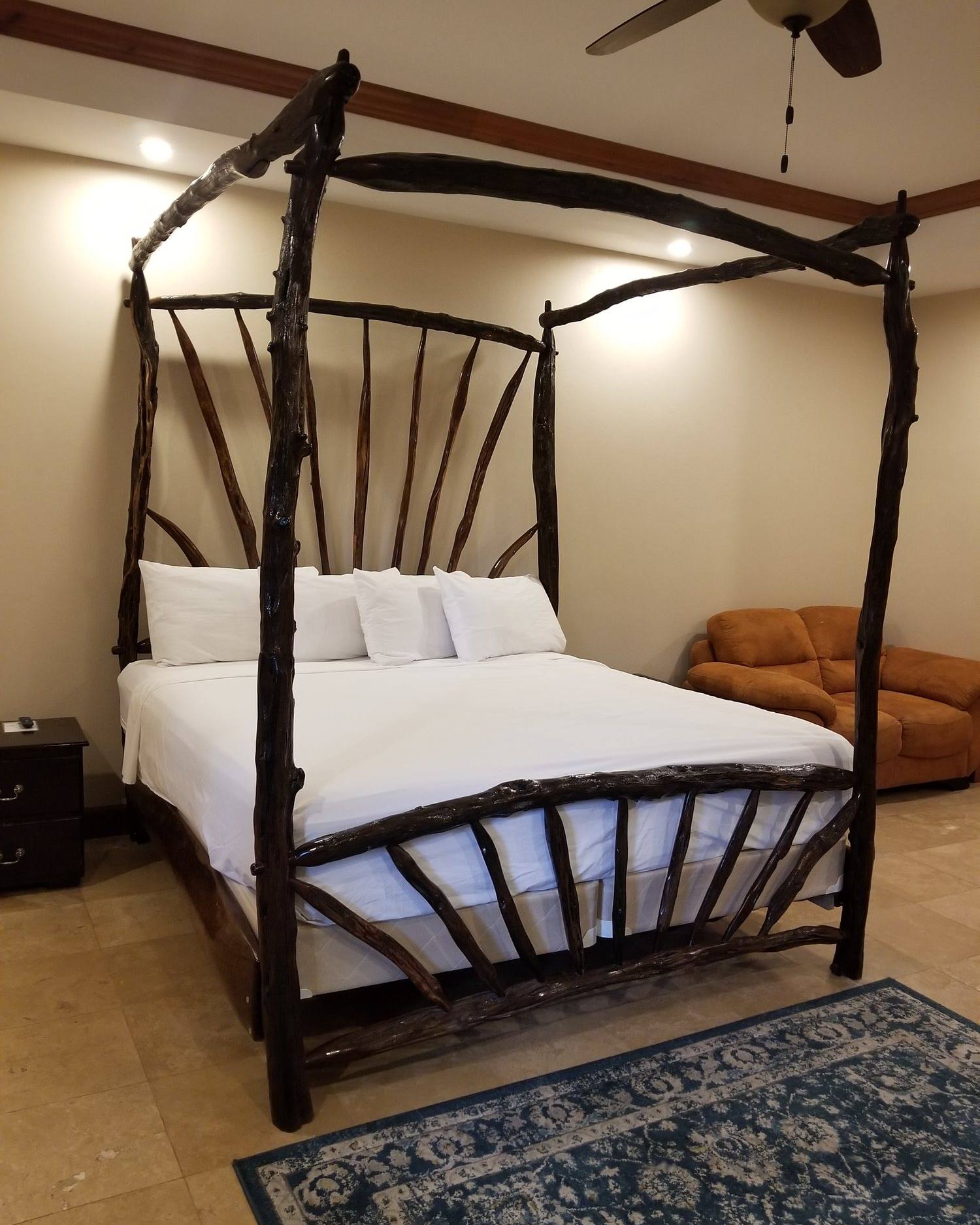 Four-poster canopy bed built from logwood branches