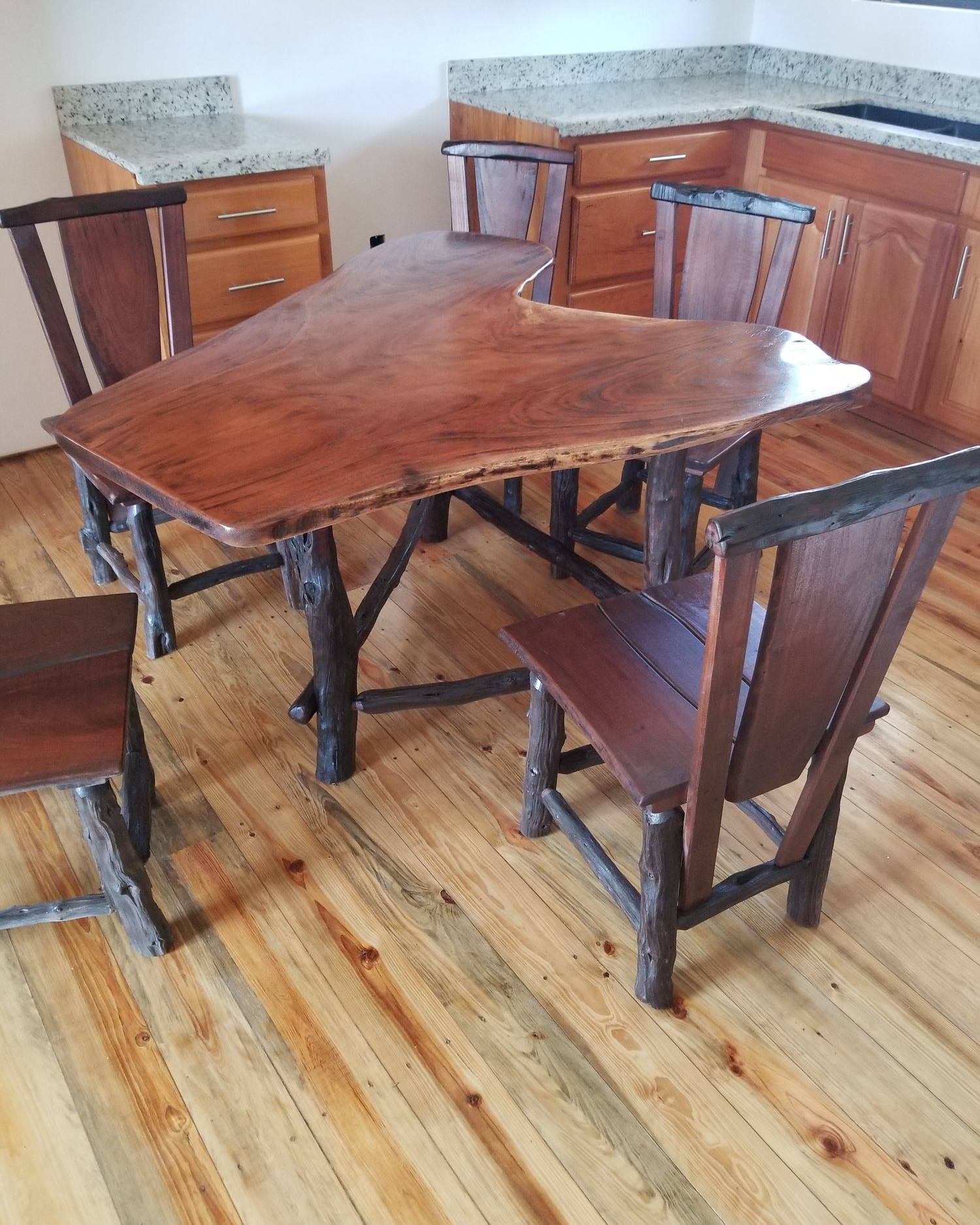 Free-form hardwood kitchen table with matching chairs on a pine floor