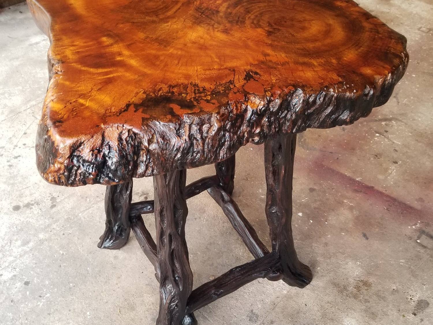 Polished live-edge logwood burl table showing crimson and gold grain