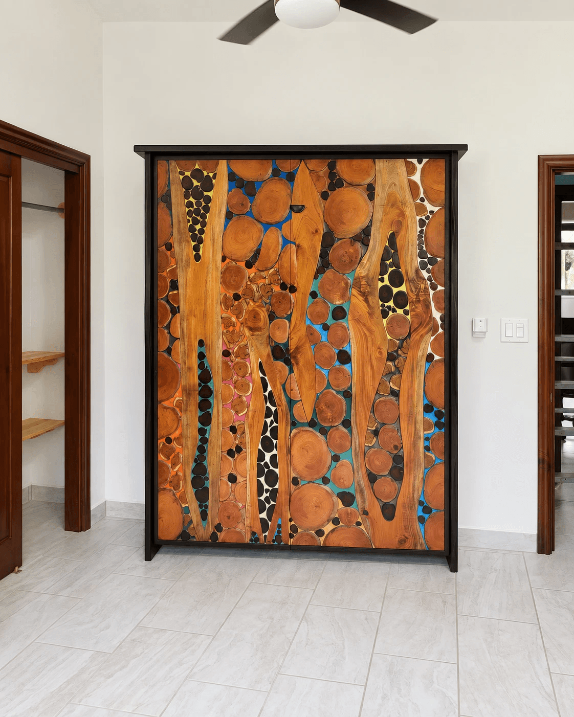 The multicolour resin Murphy bed closed against the wall of a bright tiled guest room