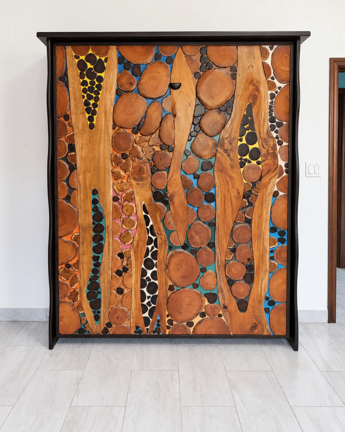 Closed Murphy bed whose front is hardwood slabs and rounds set in yellow, blue, teal, pink, orange and white epoxy resin