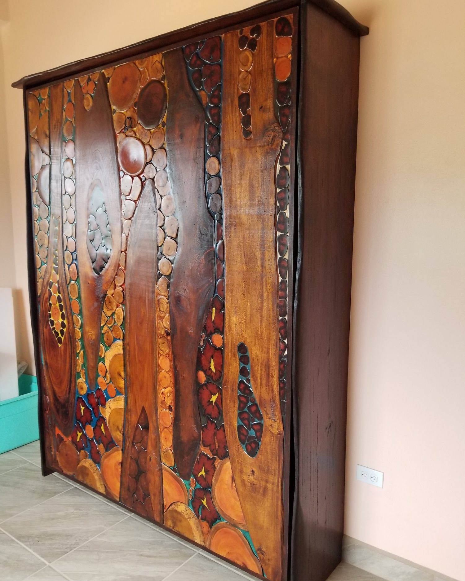 Closed Murphy bed front of mixed hardwoods with blue, red and gold pigmented resin between the pieces